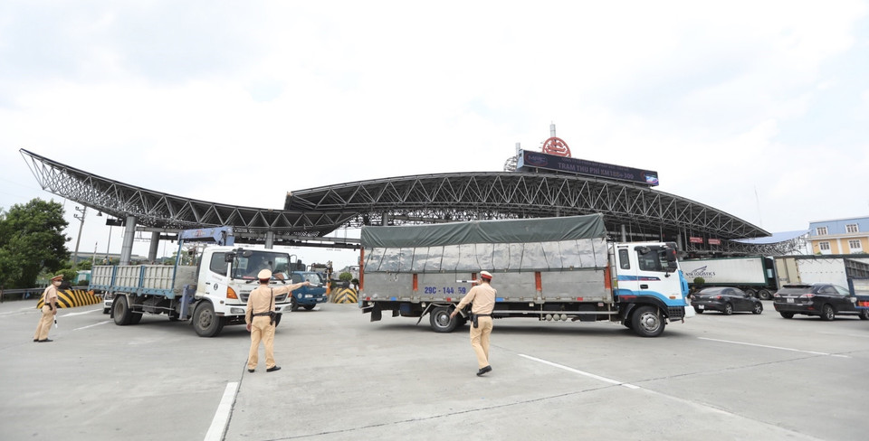 Lực lượng chức năng hướng dẫn các phương tiện quay đầu tại trạm thu phí Pháp Vân-Cầu Giẽ khi thực hiện Chỉ thị 17 của UBND thành phố. (Ảnh: Minh Quyết/TTXVN)