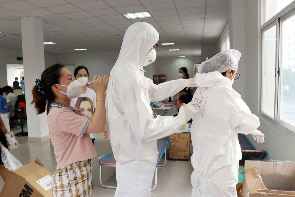 Các bác sỹ Bệnh viện dã chiến thu dung, điều trị COVID-19 số 3 phải ghi tên lên áo để nhận được nhau trong bộ đồ bảo hộ kín mít. (Ảnh: Xuân Khu/TTXVN)