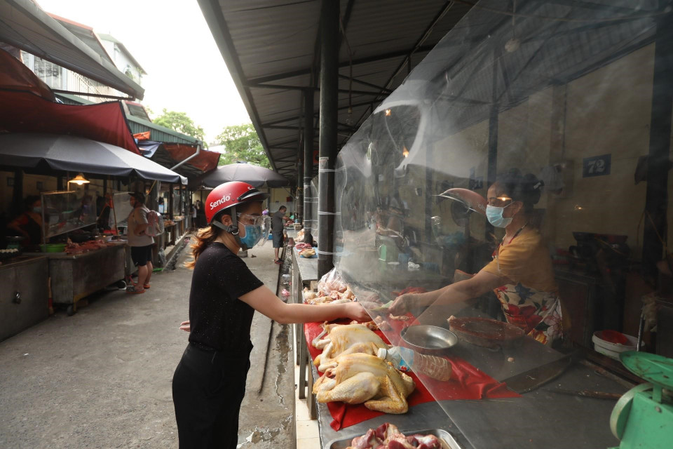 Các quầy hàng đều được lắp hàng rào nylon đảm bảo giãn cách, ngăn giọt bắn (ảnh chụp sáng 26/7). (Ảnh: Minh Quyết/TTXVN)