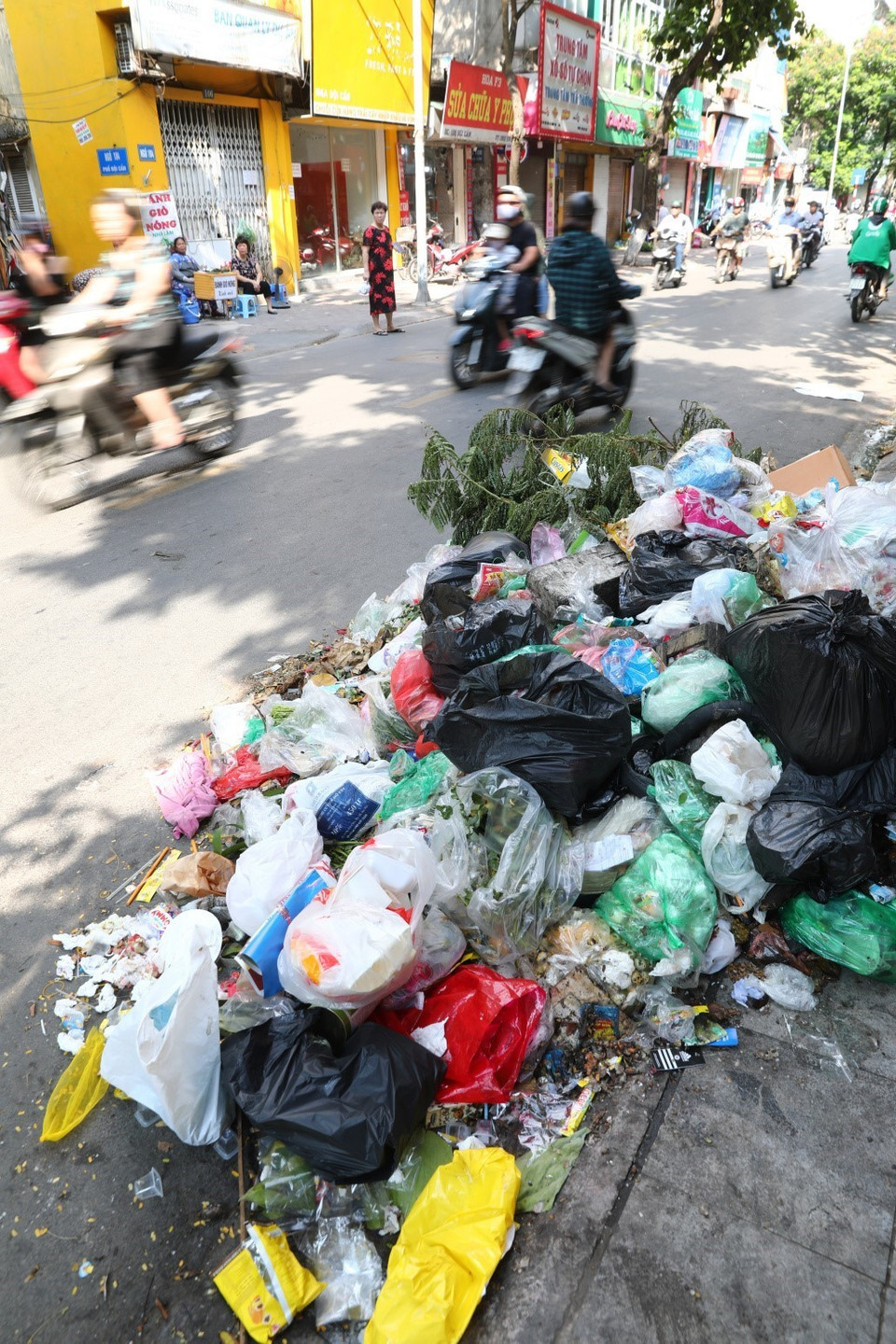 Rác thải sinh hoạt ùn ứ, tràn ra mặt đường tại rất nhiều tuyến phố trung tâm Hà Nội (ảnh chụp ngày 16/7). (Ảnh: Thành Đạt/TTXVN)