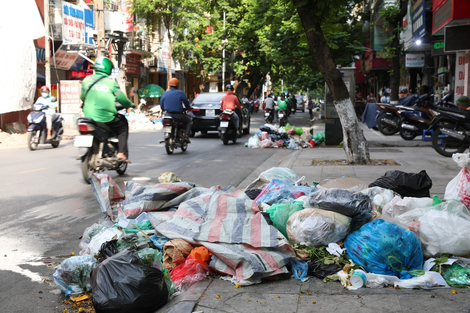 Rác thải sinh hoạt ùn ứ, tràn ra mặt đường tại rất nhiều tuyến phố trung tâm Hà Nội (ảnh chụp ngày 16/7). (Ảnh: Thành Đạt/TTXVN)