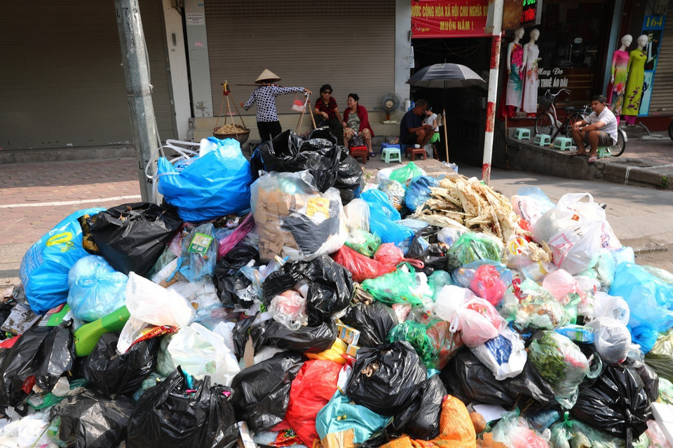 Tại khu vực phố Kim Mã rác thải ùn ứ đã 3 ngày qua, chất lên thành nhiều đống lớn gây mất vệ sinh môi trường cho người dân nơi đây (ảnh chụp ngày 16/7). (Ảnh: Thành Đạt/TTXVN)
