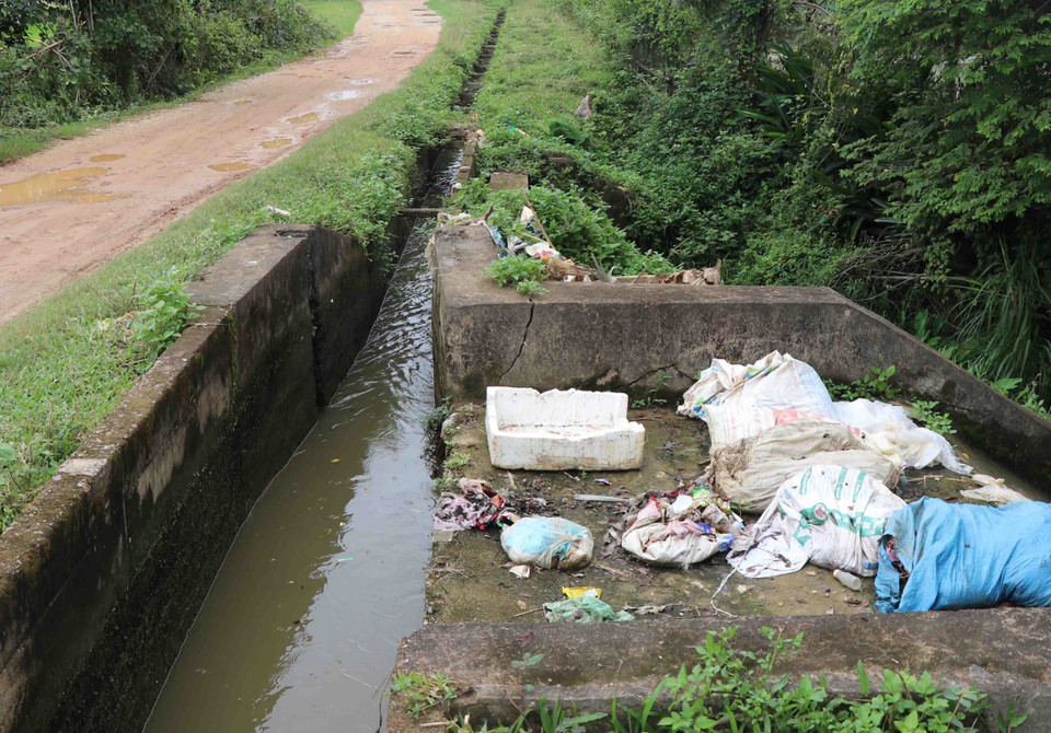Rác đổ bừa bãi khu vực đập dâng chống tràn của kênh hữu Đại thủy nông Nậm Rốm. (Ảnh: Xuân Tiến/TTXVN)