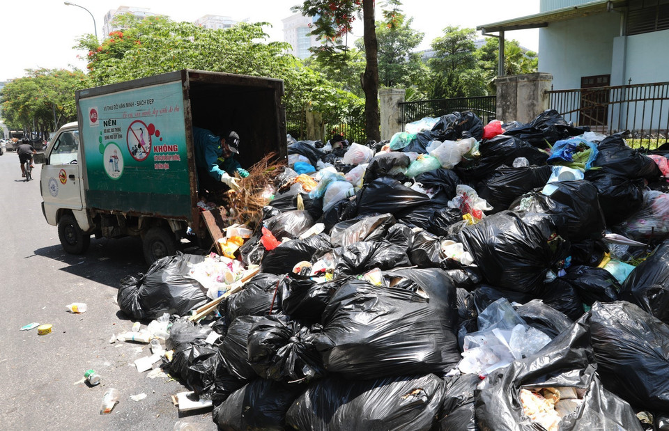 Nhân viên Công ty Môi trường phân loại rác tại khu vực Trần Hữu Dực quận Nam Từ Liêm (ảnh chụp ngày 16/7). (Ảnh: Thành Đạt/TTXVN)