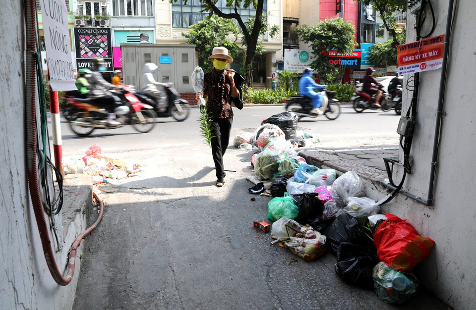 Rác thải tràn ngập từ ngõ ra đến mặt đường tại khu vực phố Kim Mã gây khó chịu cho người dân (ảnh chụp ngày 16/7). (Ảnh: Thành Đạt/TTXVN)