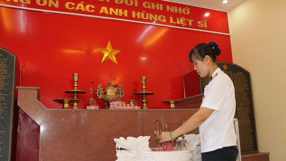 Thượng úy Trần Thị Thủy thắp hương tại phòng truyền thống tưởng niệm 64 liệt sỹ tại Lữ đoàn 146, Bộ Tư lệnh Vùng 4 Hải quân. (Ảnh: Sỹ Tuyên-Thắng Trung-Phan Sáu/TTXVN)