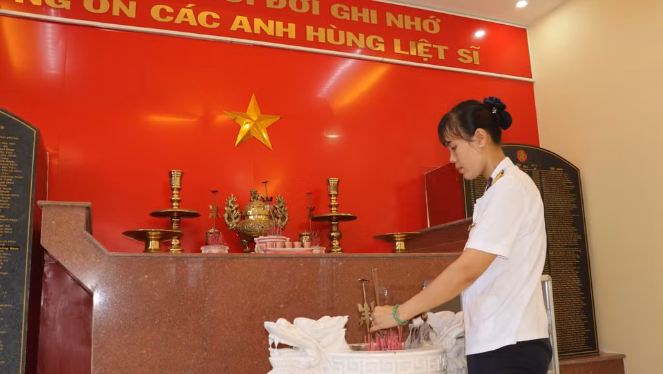 Thượng úy Trần Thị Thủy thắp hương tại phòng truyền thống tưởng niệm 64 liệt sỹ tại Lữ đoàn 146, Bộ Tư lệnh Vùng 4 Hải quân. (Ảnh: Sỹ Tuyên-Thắng Trung-Phan Sáu/TTXVN)