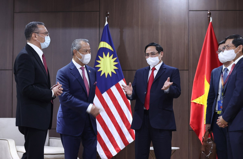 Thủ tướng Phạm Minh Chính và Thủ tướng Malaysia Muhyiddin Yassin trao đổi. (Ảnh: Dương Giang/TTXVN)