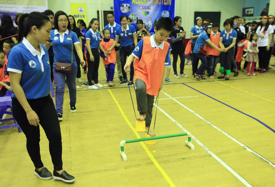 Trẻ tự kỷ tham gia trò chơi thi đi cà kheo hộp tại chương trình thể thao thân thiện, do Mạng lưới Người tự kỷ Việt Nam (VAN), ngày 2/4/2016. (Ảnh: Anh Tuấn/TTXVN)