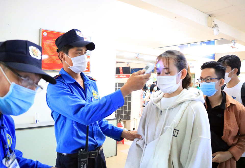 Thực hiện kiểm tra thân nhiệt tại Bến xe miền Đông. (Ảnh: Tiến Lực/TTXVN)