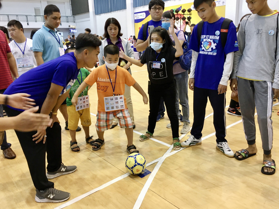 Các chuyên viên can thiệp hướng dẫn trẻ bị chứng Rối loạn phổ tự kỷ sinh sống trên địa bàn Thành phố Hồ Chí Minh chơi bóng đá. (Ảnh: Đinh Hằng/TTXVN)