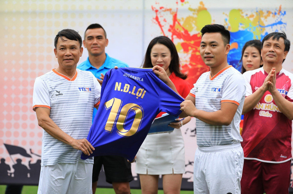 Bí thư Đoàn Thanh niên TTXVN Lê Minh Đức, đại diện thế hệ trẻ TTXVN, trao tặng chiếc áo đấu số 10 danh dự cho Tổng giám đốc Nguyễn Đức Lợi. (Ảnh: Thành Đạt/TTXVN)