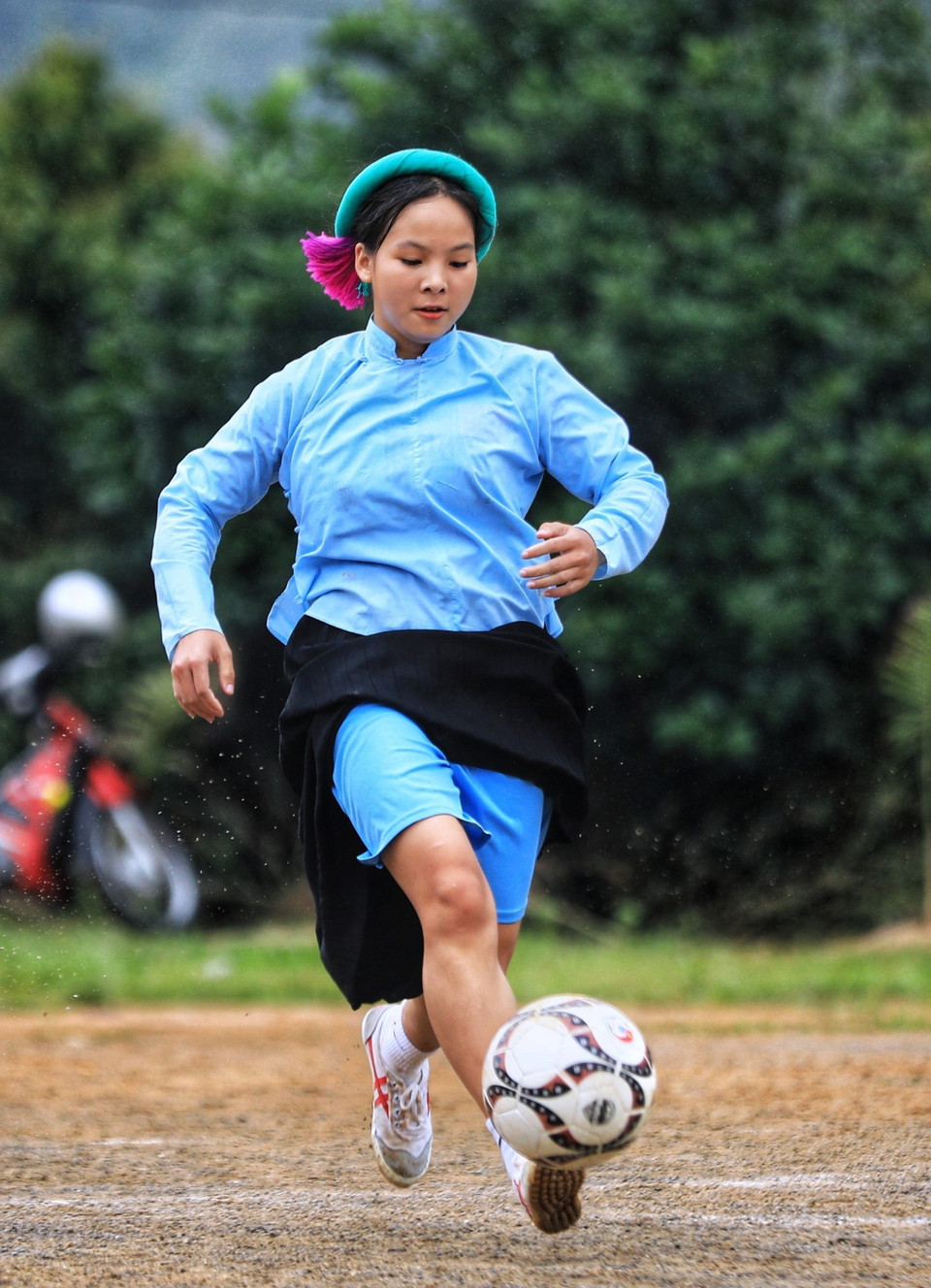 Cô gái Sán Chỉ mặc trang phục dân tộc có kỹ thuật dẫn bóng không kém các đấng nam nhi. (Ảnh: Thành Đạt/TTXVN)