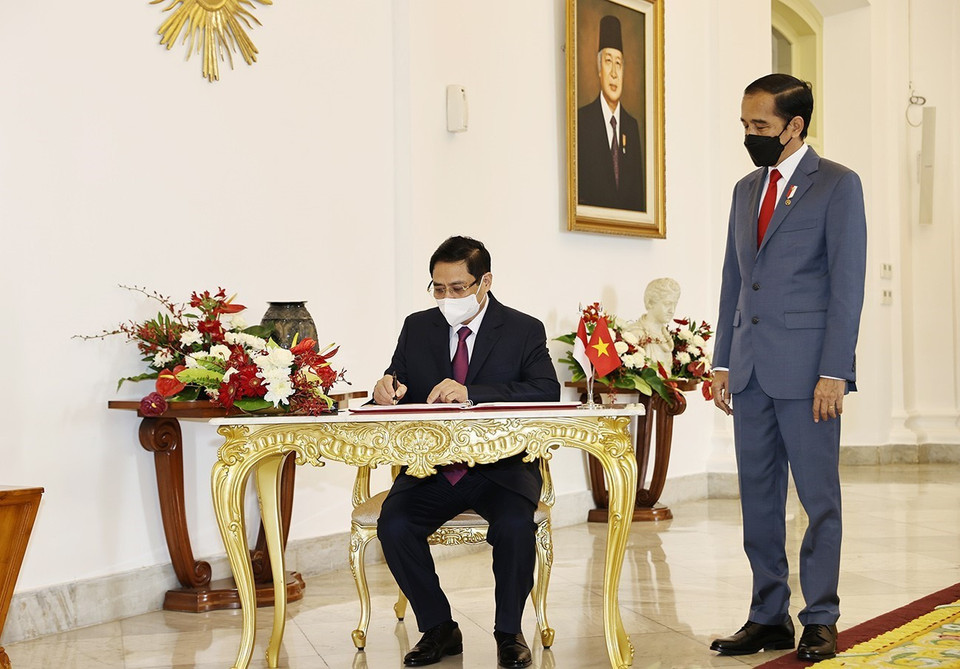 Thủ tướng Phạm Minh Chính ký sổ lưu niệm. (Ảnh: Dương Giang/TTXVN)