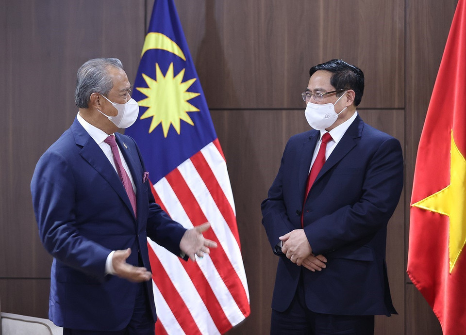 Thủ tướng Phạm Minh Chính và Thủ tướng Malaysia Muhyiddin Yassin trao đổi. (Ảnh: Dương Giang/TTXVN)