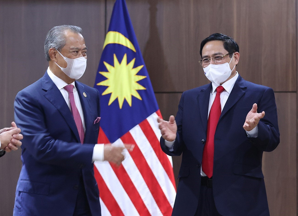 Thủ tướng Phạm Minh Chính và Thủ tướng Malaysia Muhyiddin Yassin trao đổi. (Ảnh: Dương Giang/TTXVN)