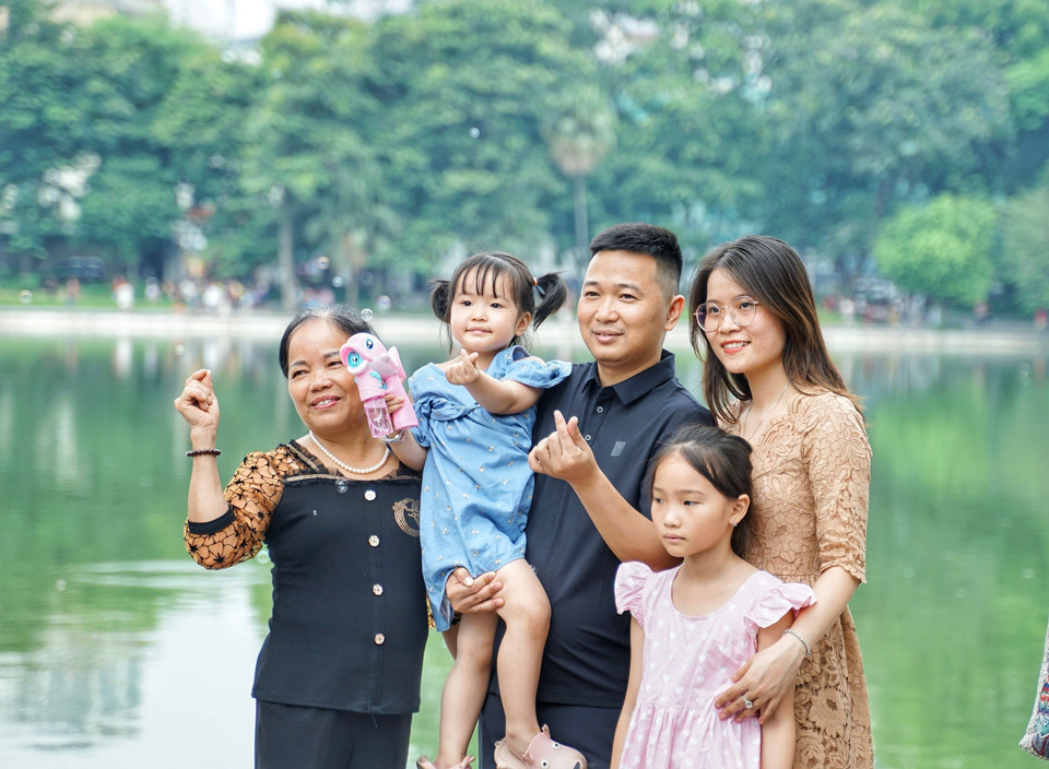 Một trong nhiều gia đình tham quan hồ Hoàn Kiếm dịp nghỉ Lễ 2/9. (Ảnh: Khánh Hòa/TTXVN)