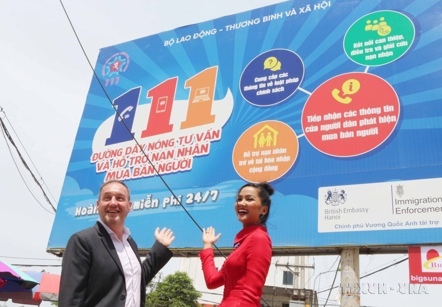 Phó Đại sứ Vương quốc Anh Stephen Lysaght và Hoa hậu H’hen Niê truyền thông điệp về Nâng cao nhận thức phòng chống mua bán người tại Lễ khánh thành biển truyền thông Đường dây nóng tư vấn và hỗ trợ nạn nhân mua bán người 111 do Đại sứ quán Vương quốc Anh, Cục Trẻ em-Bộ Lao động, Thương binh và Xã hội cùng đại diện tỉnh Nghệ An tổ chức (22/5/2020). (Ảnh: Nguyễn Oanh/TTXVN)