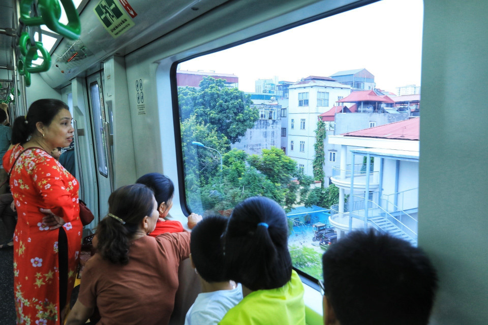 Người dân ngắm phố phường Hà Nội từ trong tàu điện. (Ảnh: Tuấn Anh/TTXVN)