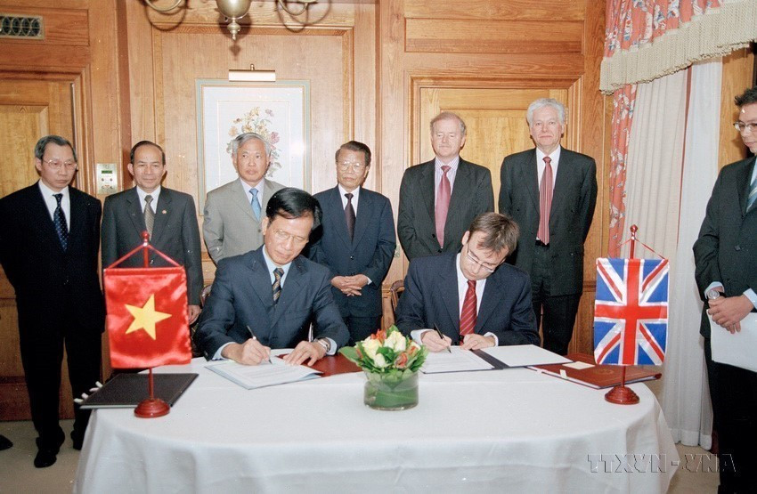 Chủ tịch nước Trần Đức Lương chứng kiến Lễ ký các văn kiện về viện trợ phát triển của Anh cho Việt Nam, trong chuyến thăm chính thức Vương quốc Anh, tháng 5/2004. (Ảnh: Nguyễn Khang/TTXVN)
