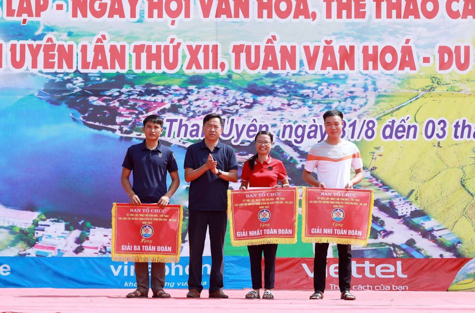 Phó Chủ tịch Ủy ban Nhân dân huyện Than Uyên, Trần Quang Chiến, trưởng ban tổ chức Ngày hội Văn hóa Các Dân tộc Than Uyên trao giải Nhất, Nhì, Ba toàn đoàn cho các đơn vị. (Ảnh: Quý Trung/TTXVN)