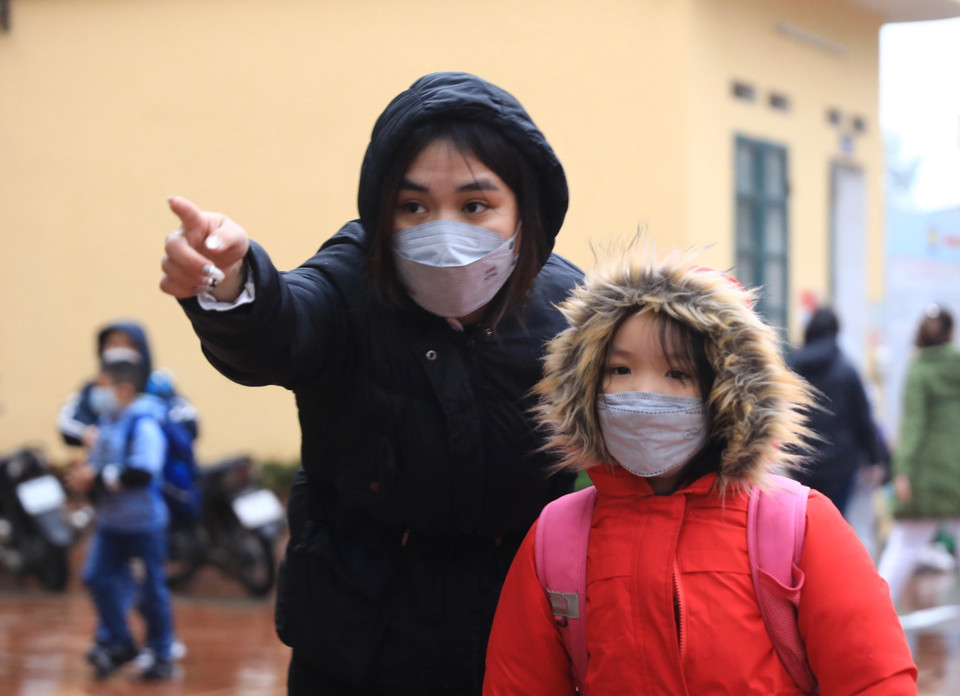 Giáo viên Trường tiểu học Thanh Liệt (Thanh Trì) hướng dẫn các em vị trí lớp học. (Ảnh: Hoàng Hiếu/TTXVN)