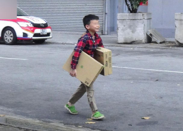 Cậu bé mừng rỡ sau khi lấy được hai thùng khoai tây. (Nguồn: QQ)