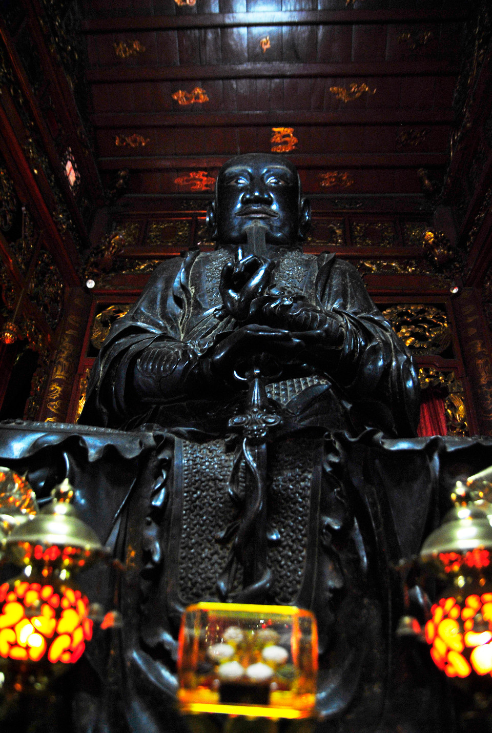 Pho Tượng Huyền Thiên Trấn Vũ được đúc bằng đồng đen. Tượng cao khoảng 3,96m, chu vi 8m, mặt vuông, mắt nhìn thẳng, râu dài, tóc xoã không đội mũ, mặc áo đạo sĩ, ngồi trên bục đá, tay trái bắt quyết, tay phải chống gươm có rắn quấn và chống lên lưng rùa. (Ảnh: Võ Phương/Vietnam+)