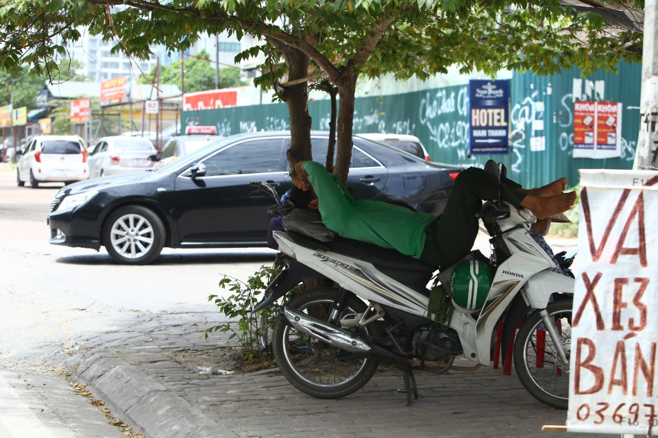 Nhiều người tranh thủ tránh nắng dưới bóng cây. (Ảnh: Minh Quyết/TTXVN)