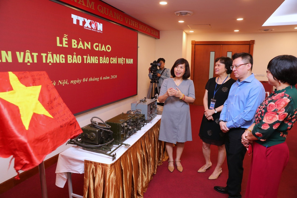 Ông Lê Quốc Minh, Phó Tổng giám đốc, Chủ tịch Liên Chi hội Nhà báo TTXVN, cùng các đại biểu tham quan các hiện vật quý về Báo chí Việt Nam. (Ảnh: Thành Đạt/TTXVN)