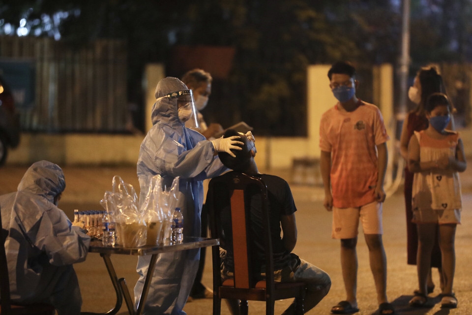 Nhân viên y tế lấy mẫu cho người dân tổ 7, phường Việt Hưng tối 19/9/2021. (Ảnh: Minh Quyết/TTXVN)