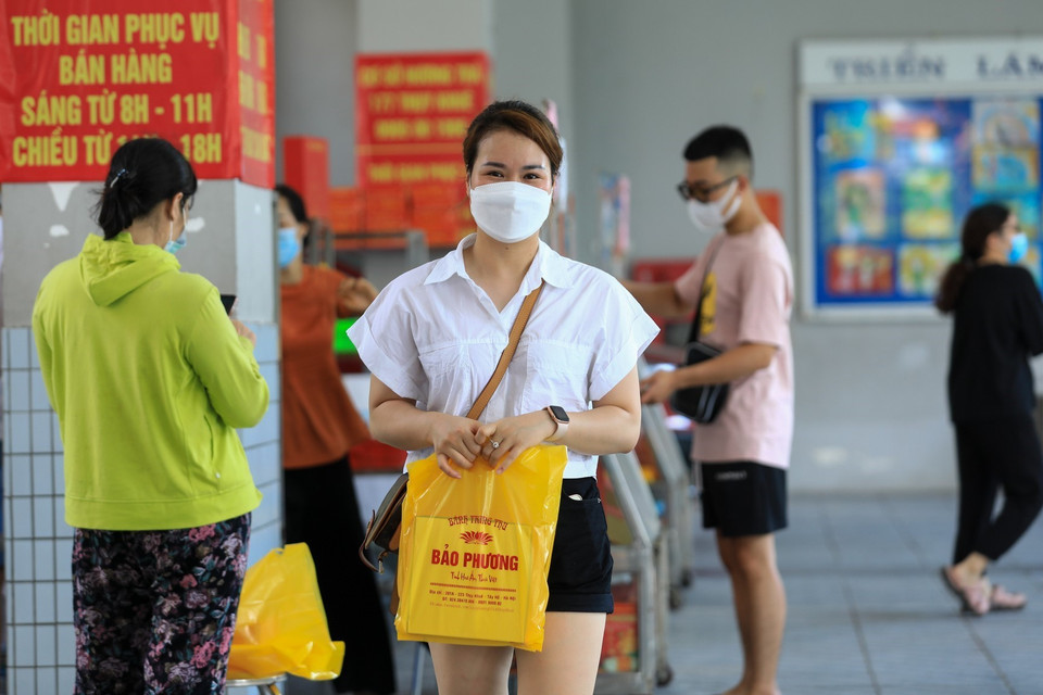 Người dân mua được hộp bánh Trung Thu truyền thống sau khi phải xếp hàng từ ngoài phố Thụy Khuê. (Ảnh: Thành Đạt/TTXVN)