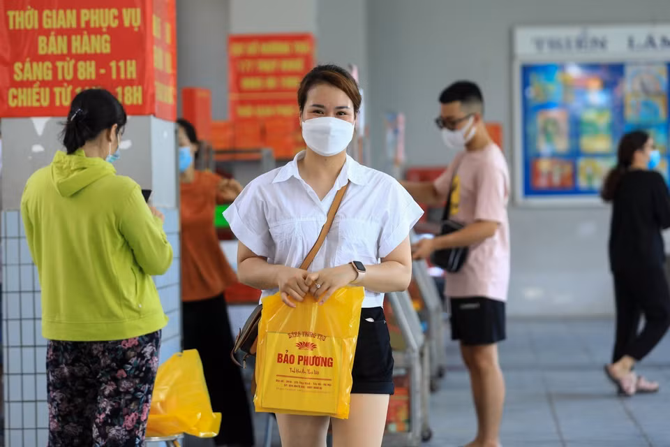 Người dân mua được hộp bánh Trung Thu truyền thống sau khi phải xếp hàng từ ngoài phố Thụy Khuê. (Ảnh: Thành Đạt/TTXVN)
