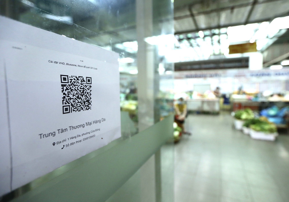Tại lối vào Trung tâm thương mại Hàng Da (phường Cửa Đông, Hoàn Kiếm) có dán mã QR để người dân vào chợ tiện khai báo trực tuyến. (Ảnh: Hoàng Hiếu/TTXVN)