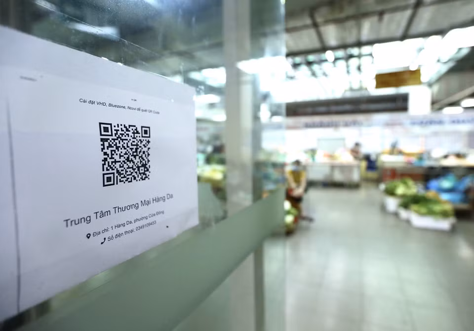 Tại lối vào Trung tâm thương mại Hàng Da (phường Cửa Đông, Hoàn Kiếm) có dán mã QR để người dân vào chợ tiện khai báo trực tuyến. (Ảnh: Hoàng Hiếu/TTXVN)