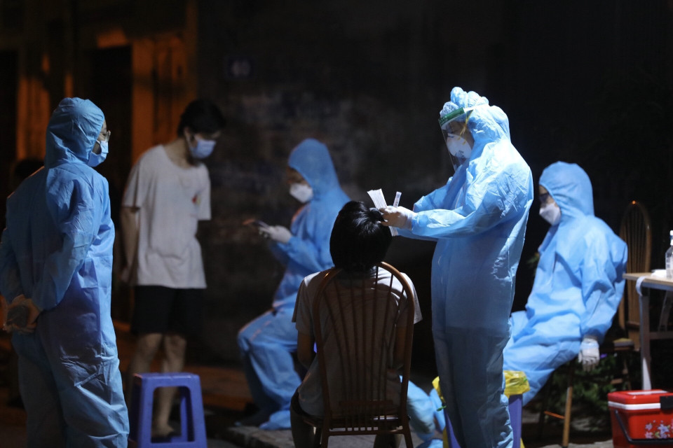 Nhân viên y tế lấy mẫu cho người dân tổ 5, phường Việt Hưng tối 19/9/2021. (Ảnh: Minh Quyết/TTXVN)