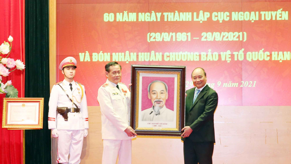Chủ tịch nước Nguyễn Xuân Phúc trao bức chân dung Chủ tịch Hồ Chí Minh tặng Cục Ngoại tuyến, Bộ Công an. (Ảnh: Phạm Kiên/TTXVN)