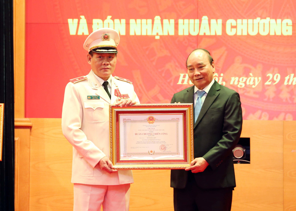 Chủ tịch nước Nguyễn Xuân Phúc trao tặng Huân chương Chiến công hạng Nhì cho Thiếu tướng Đoàn Hùng Sơn, Cục trưởng Cục Ngoại tuyến, Bộ Công an. (Ảnh: Phạm Kiên/TTXVN)