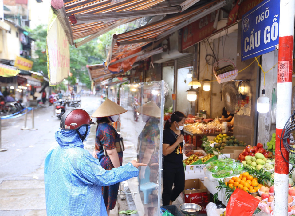 Các quầy hàng chợ Hàng Bè (Hàng Bạc, Hoàn Kiếm) đều lắp tấm chắn giọt bắn giúp các tiểu thương và người mua hàng đảm bảo phòng, chống dịch hiệu quả. (Ảnh: Hoàng Hiếu/TTXVN)