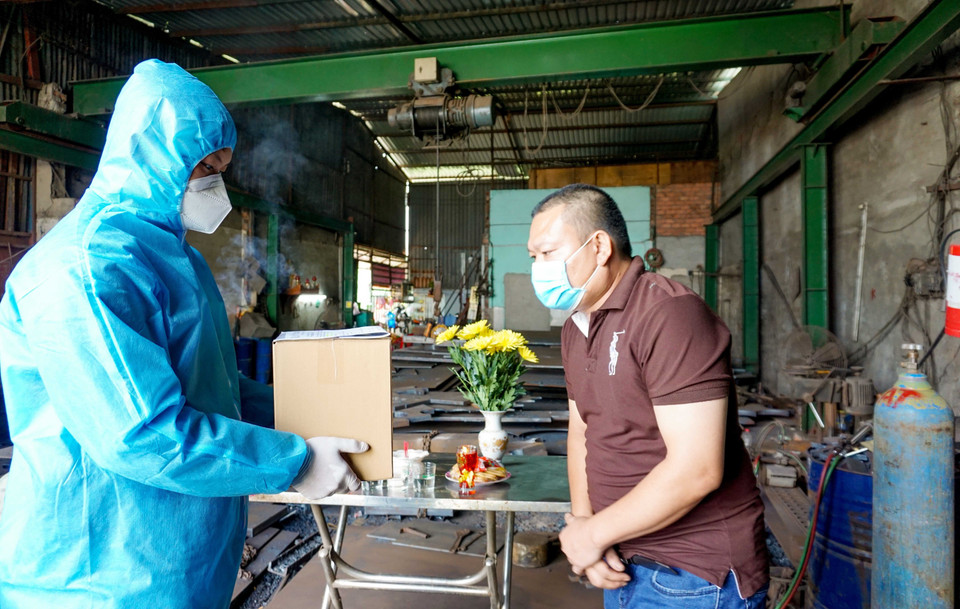 Cán bộ, chiến sỹ Ban Chỉ huy quân sự quận Bình Chánh bàn giao tro cốt người mất vì COVID-19 cho nhân thân. (Ảnh: Xuân Khu/TTXVN)