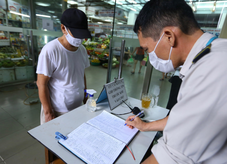 Trung tâm thương mại Hàng Da (Hoàn Kiếm, Hà Nội) ghi thông tin tất cả những người đến mua, bán hàng tại chợ. (Ảnh: Hoàng Hiếu/TTXVN)