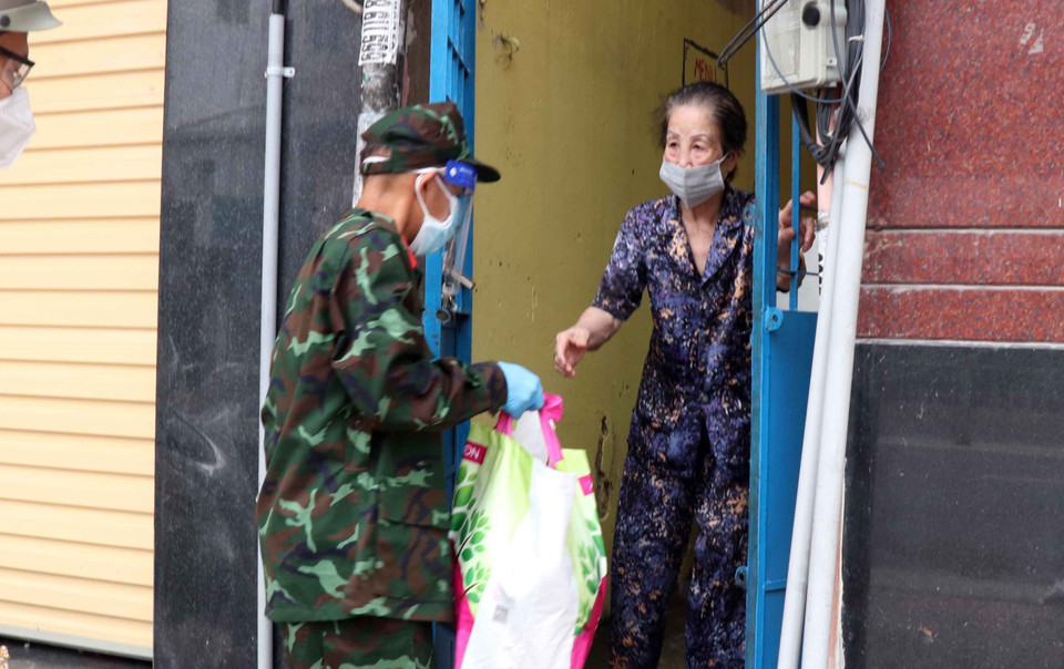 Lực lượng quân đội tăng cường trao lương thực thực phẩm cho người dân Thành phố. (Ảnh: Xuân Khu/TTXVN)