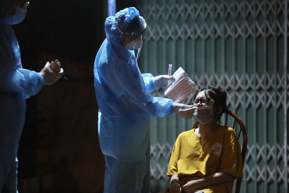 Nhân viên y tế lấy mẫu cho người dân tổ 5, phường Việt Hưng tối 19/9/2021. (Ảnh: Minh Quyết/TTXVN)