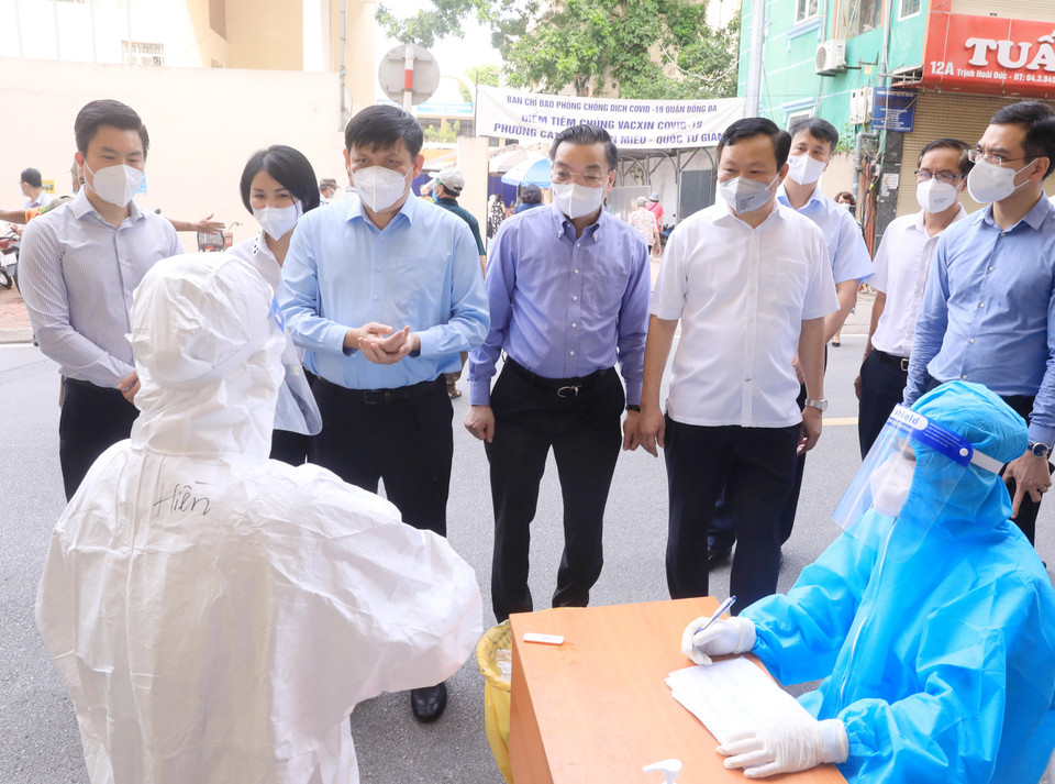 Bộ trưởng Bộ Y tế Nguyễn Thanh Long và Chủ tịch Ủy ban Nhân dân thành phố Hà Nội Chu Ngọc Anh kiểm tra việc xét nghiệm nhanh trước khi tiêm vaccine cho người dân. (Ảnh: Lâm Khánh/TTXVN)