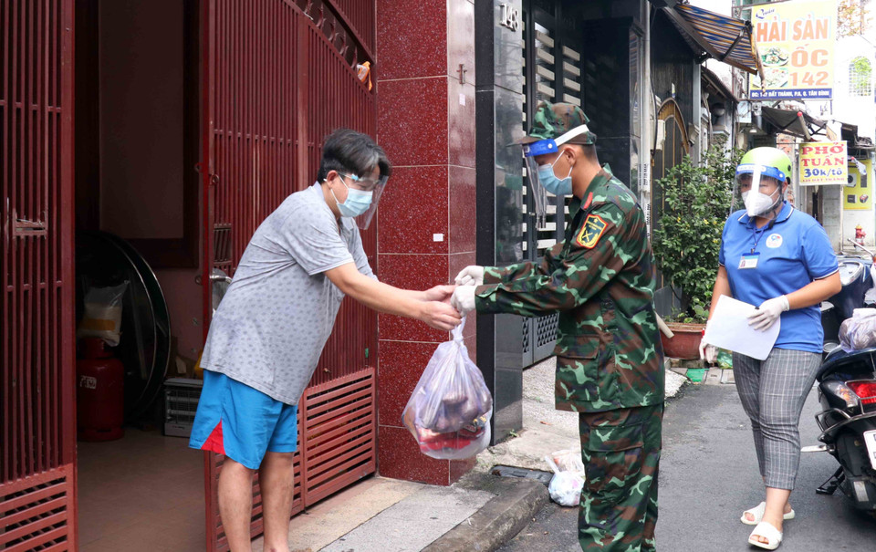 Cán bộ, chiến sỹ Sư đoàn 309 vận chuyển quà tặng nhu yếu phẩm sinh hoạt đến cho người dân tại phường 6, quận Tân Bình. (Ảnh: Xuân Khu-TTXVN)