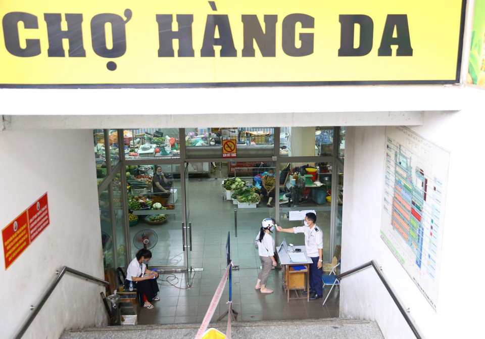 Người dân khi đến Trung tâm thương mại Hàng Da (phường Cửa Đông, Hoàn Kiếm) được kiểm tra thân nhiệt ngay lối vào. (Ảnh: Hoàng Hiếu/TTXVN)