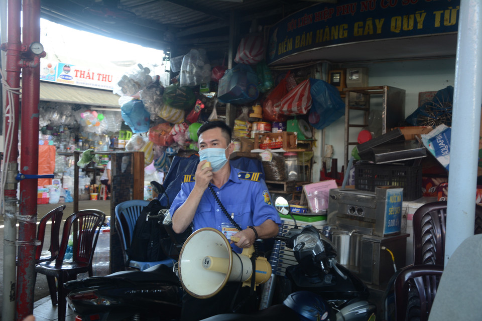 Quản lý Chợ Cồn thường xuyên nhắc nhở người dân thực hiện Thông điệp 5K của Bộ Y tế. (Ảnh: Văn Dũng/TTXVN)