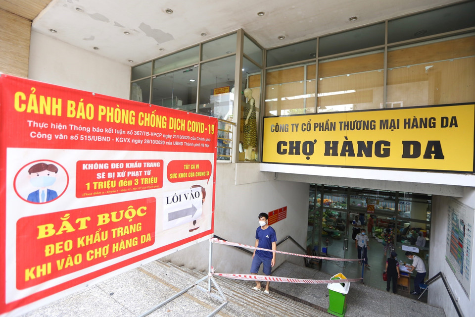 Trung tâm thương mại Hàng Da (Hoàn Kiếm, Hà Nội) yêu cầu người dân vào chợ bắt buộc phải đeo khẩu trang và có lối ra, vào riêng nhằm đảm bảo giãn cách phòng chống dịch. (Ảnh: Hoàng Hiếu/TTXVN)