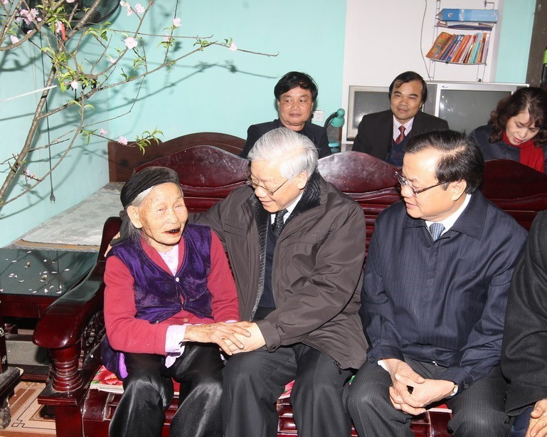 Tổng Bí thư Nguyễn Phú Trọng chúc Tết và tặng quà cụ Kiều Thị Xe, thôn Hương Lam, xã Đại Đồng, huyện Thạch Thất, Hà Nội (2013). (Ảnh: Trí Dũng/TTXVN)