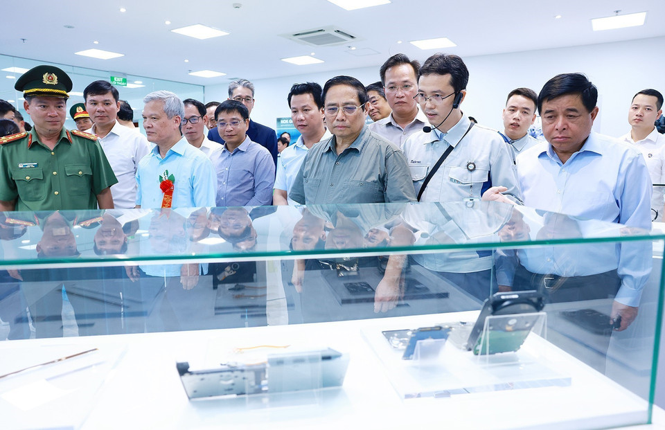 Thủ tướng Phạm Minh Chính xem sản phẩm bản mạch của Công ty TNHH Mektec Manufacturing chuyên sản xuất bản mạch. (Ảnh: Dương Giang/TTXVN)